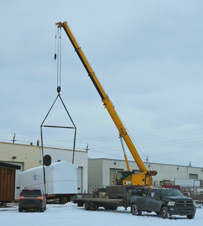 A crane is attached to a home.