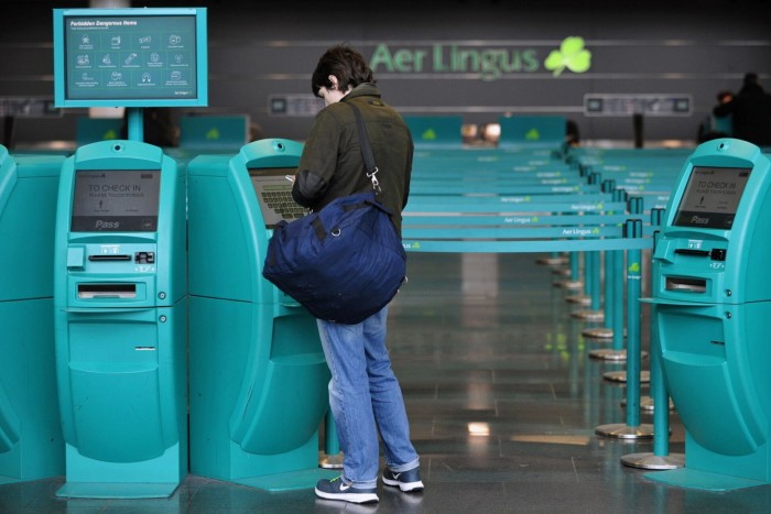 A customers uses an automated self check-in machine near the Aer Lingus Group Plc check-in desk in the departure hall at Dublin Airport, 