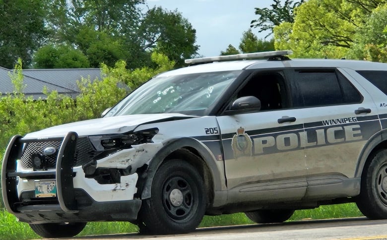 A police car with bullet holes in the windshield.