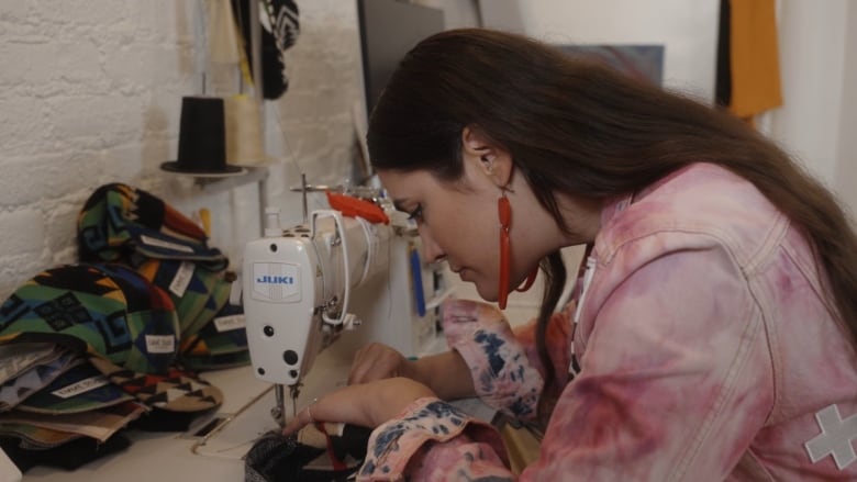 A woman working at a sewing machine. 