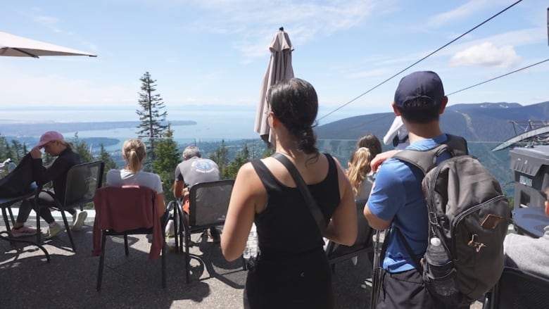 People sit on a patio on top of Grouse Mountain. 