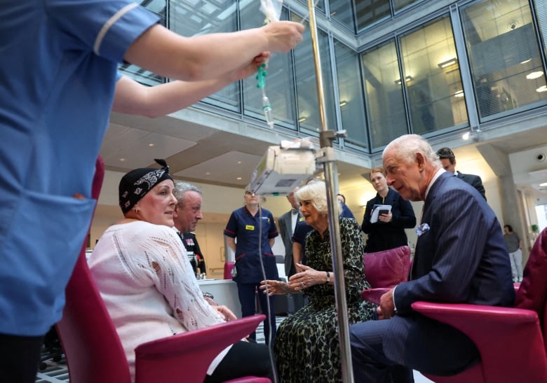 A circle of people sit in a  hospital  lobby