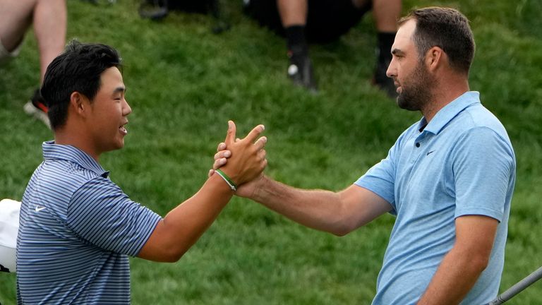 Scottie Scheffler, right, shakes hands with Tom Kim, of South Korea, after winning the Travelers Championship golf tournament at TPC River Highlands, Sunday, June 23, 2024, in Cromwell, Conn. (AP Photo/Seth Wenig)