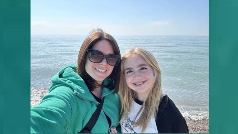 A mother and her daughter on a beach.