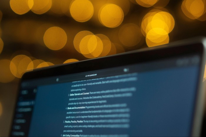 A close-up of a laptop screen displaying text, with the browser tab showing “chat.openai.com.”