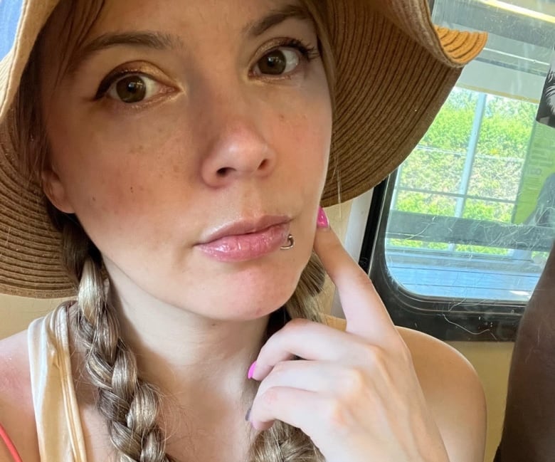 A woman with her hair in braids  looks  at  the camera