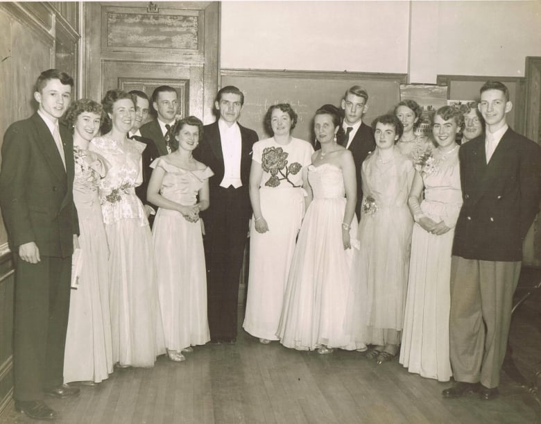 A black and white shows 15 high school students dressed in formal wear, likely at a February 1951 school dance.