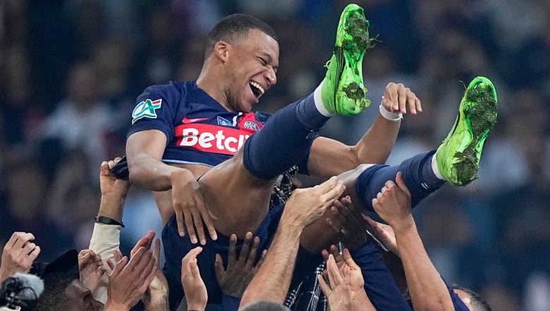 Soccer player tossed in the air by his teammates.