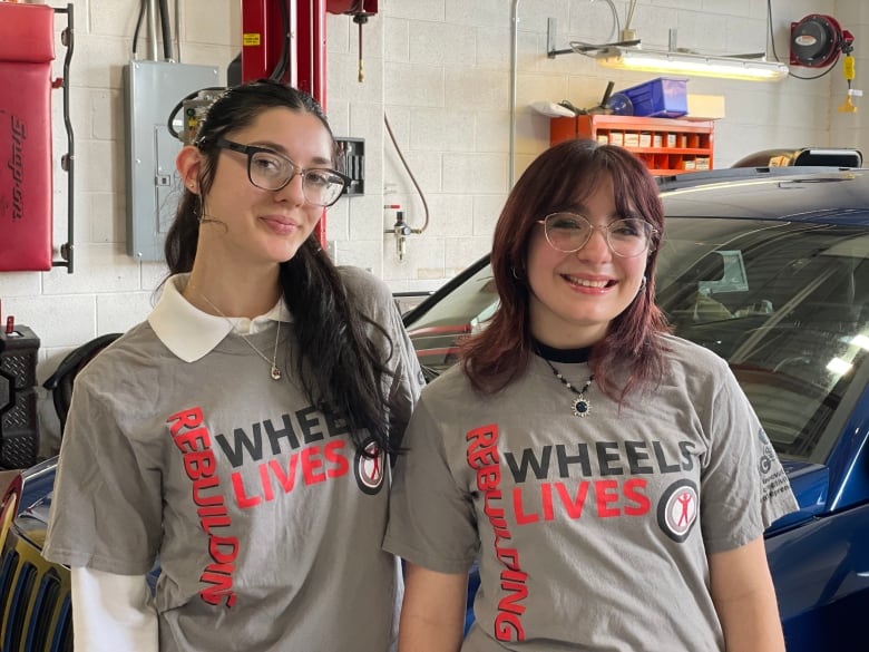 Two students wearing matching t-shirts. 