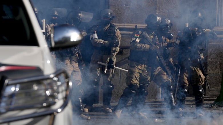 Military Police stand amid tear gas they fired.