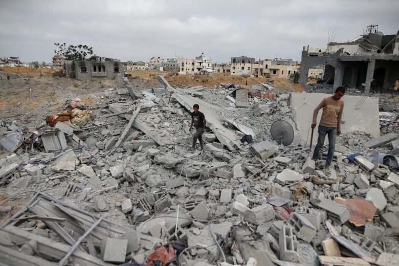 Palestinians look at the destruction after an Israeli airstrike in Khan Younis, Gaza Strip, Monday, June 3, 2024.