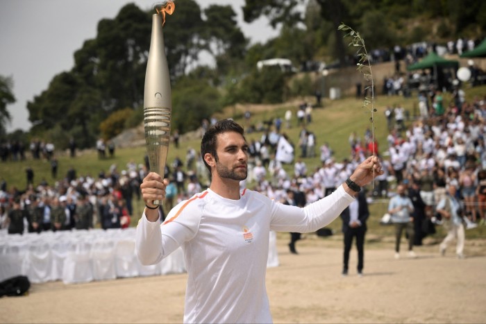 Photo of a man holding up the Olympic torch