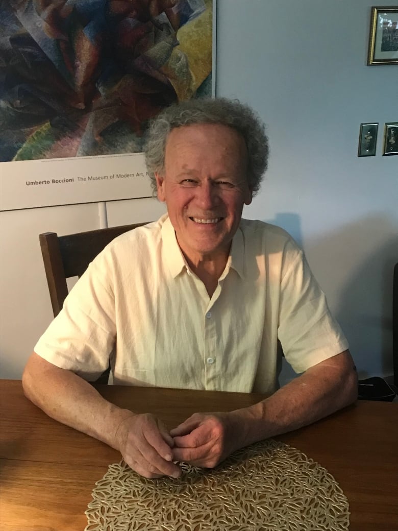 A smiling man sits at a table.