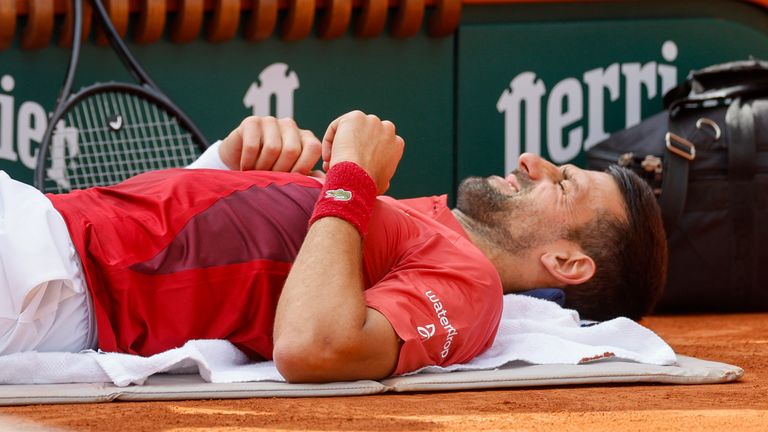 Serbia's Novak Djokovic receives medical assistance for his right knee during his fourth round match of the French Open tennis tournament against Argentina's Francisco Cerundolo at the Roland Garros stadium in Paris, Monday, June 3, 2024. (AP Photo/Jean-Francois Badias)