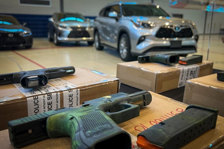 Handguns are pictured near recovered stolen cars during a Toronto Police Service press conference in Toronto, Ontario on Wednesday, March 27, 2024.