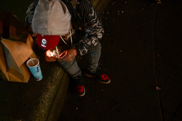  A person is using fentanyl on Park Avenue following the decriminalization of all drugs in downtown Portland, Oregon