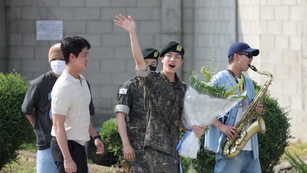 BTS star Jin celebrates in uniform after completing mandatory military service