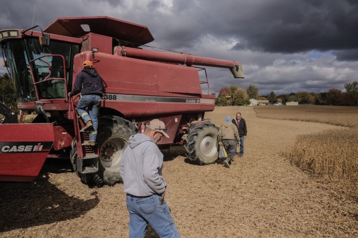 Workers prepare a combine harvester at a soyabean field in Waynesfield, Ohio