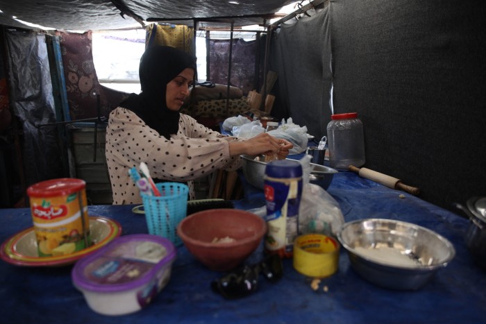 A Palestinian woman works in a makeshift kitchen