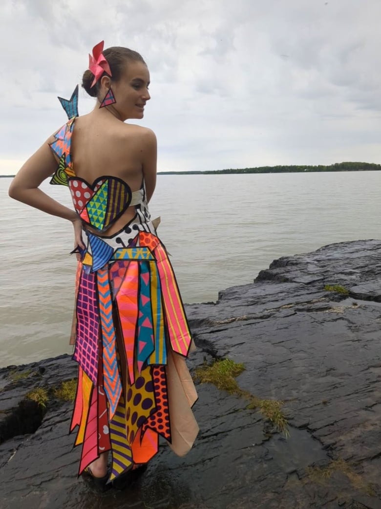 Monica Walsh poses in her duct tape prom dress, filled with vivid colours like bright blue, orange, yellow, with designs and some duct tape accessories