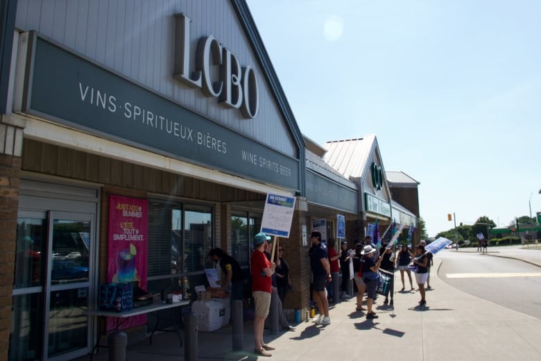 A picket line on a sidewalk outside an LCBO.