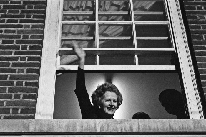 Margaret Thatcher waves from the window of Conservative party headquarters after winning