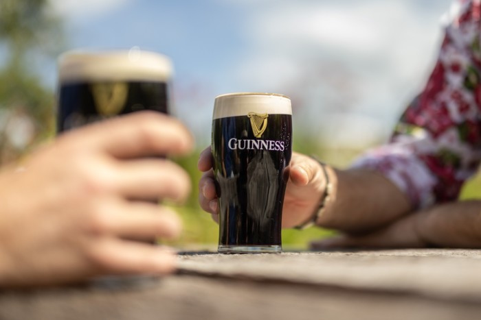 Customers drink pints of Guinness in a pub in Sussex