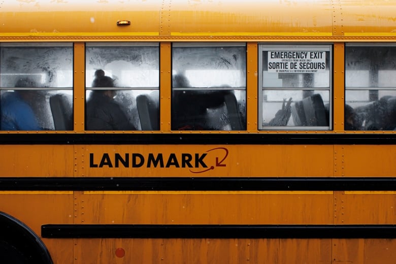 Passengers on a yellow school bus are pictured.