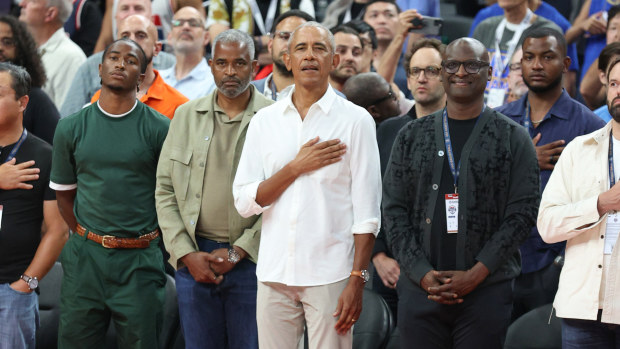 Former US President Barack Obama stands during the national anthem.