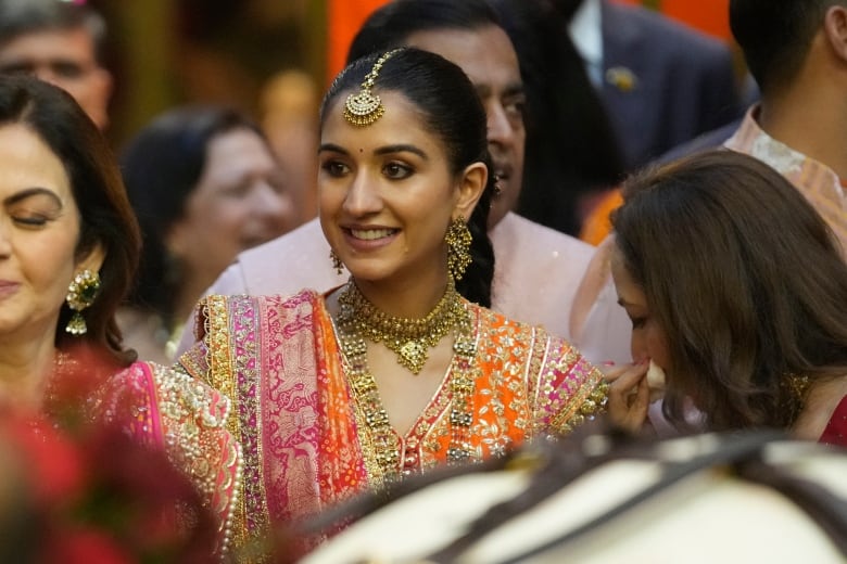 A woman in a crowd smiles.