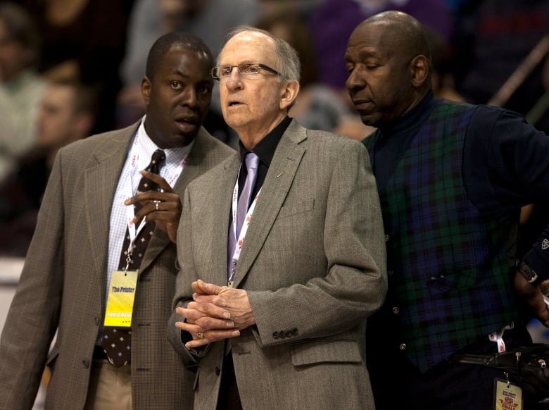 Three basketball coaches on the sidelines.