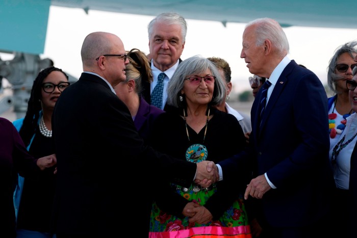 President Joe Biden greets people after arriving in Las Vegas on Monday evening