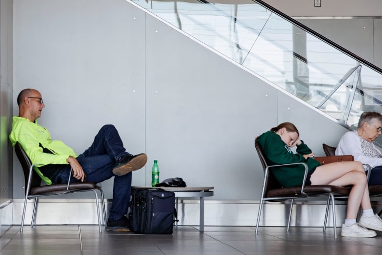 Airline passengers wait at Toronto's Billy Bishop airport after Porter Airlines cancelled flights on account of a global cybersecurity software failure that caused a series of cascading problems.