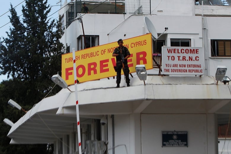 A special police sniper stands guard on the police building by a sign reading "Turkish Republic of northern Cyprus" before US Vice President Joe Biden crosses the "Ledras checkpoint to the Turkish Cypriot breakaway north for a meeting with Turkish Cypriot leader Dervis Eroglu in the divided capital Nicosia, Thursday, May 22, 2014. Biden is in Cyprus for an official, two-day visit to the ethnically divided island. Biden underscored Cyprus� potential to become key provider of natural gas to Europe, saying that newly discovered offshore reserves of the fossil fuel represented a unique opportunity for the divided island nation. 