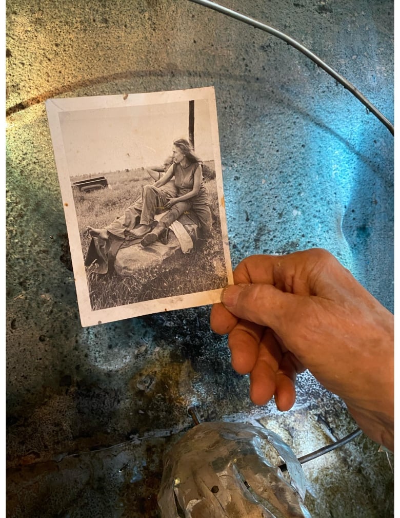 Leaf holds a photo of her and Robert Frank inside her studio. 