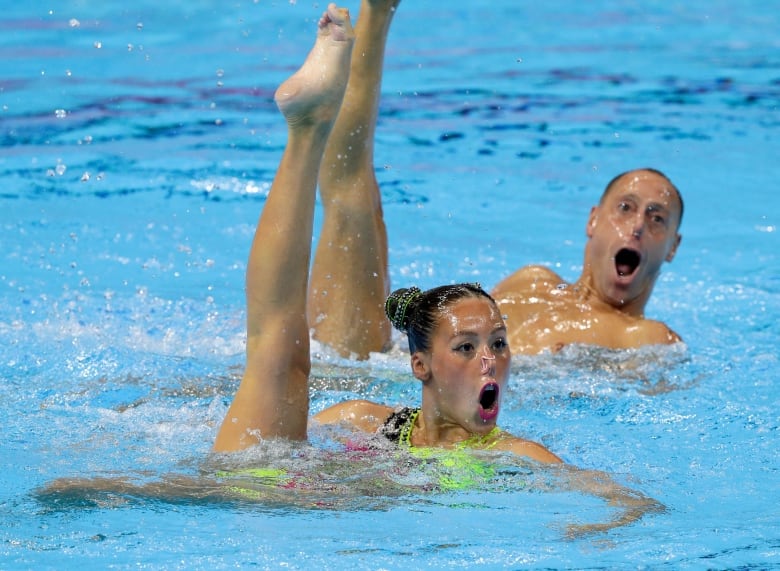 A man and women perform an artistic swimming routine