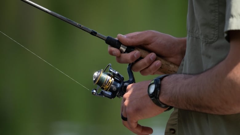 Hands of a man with hold a fish rod