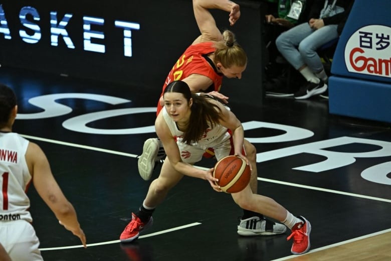 A basketball player grabs a rebound.