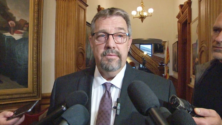  Man surrounded by microphones.