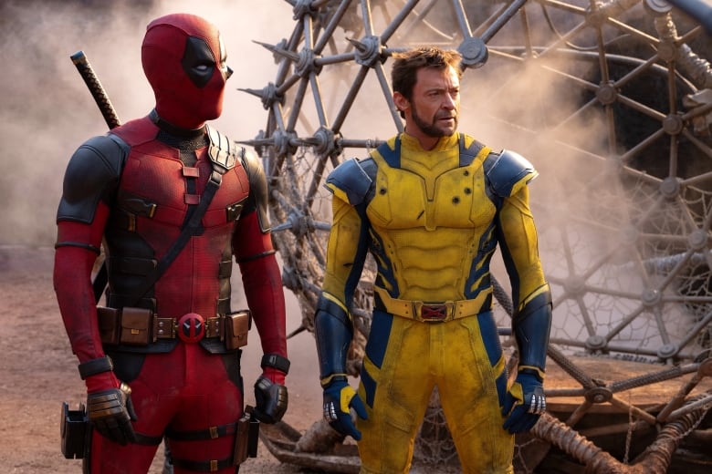 Ryan reynolds dressed as deadpool on left and Hugh jackmon dressed as Wolverine on right, looking off screen to the right.