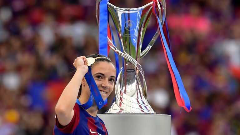 Barcelona's Aitana Bonmati holding up her medal walks past the trophy after winning the women's Champions League final soccer match between FC Barcelona and Olympique Lyonnais at the San Mames stadium in Bilbao, Spain, Saturday, May 25, 2024. Barcelona won 2-0. (AP Photo/Alvaro Barrientos)