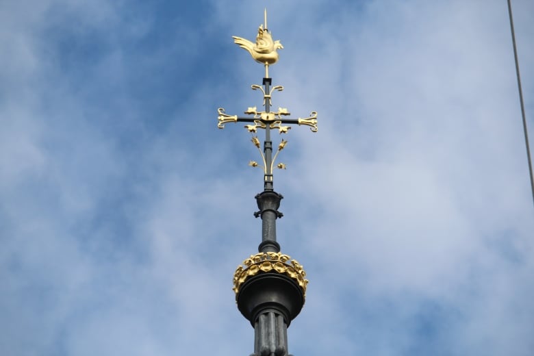 A gold rooster on top of a cathedral spire.