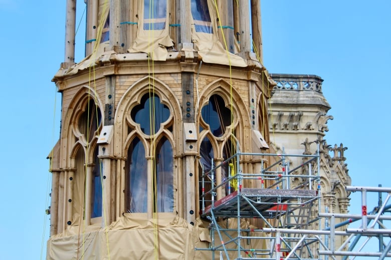 A close-up of the outside of a cathedral with scaffolding next to it.