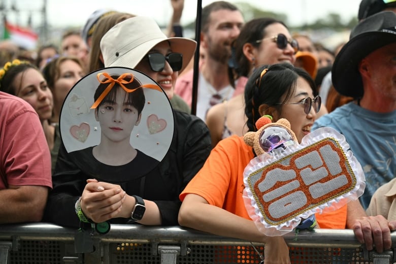 Fans with signs at a concert. 