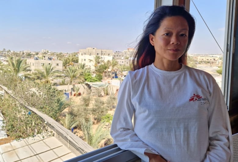 Canadian nurse Amy Kit-Mei Lowe standing on a balcony in Gaza. Lowe works with Doctors Without Borders at Nasser Hospital in Khan Younis. She says the facility is struggling to treat the influx of critically injured patients because supplies are quickly dwindling. 