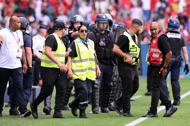 Armed police are seen on the sidelines at Stade Geoffroy-Guichard.