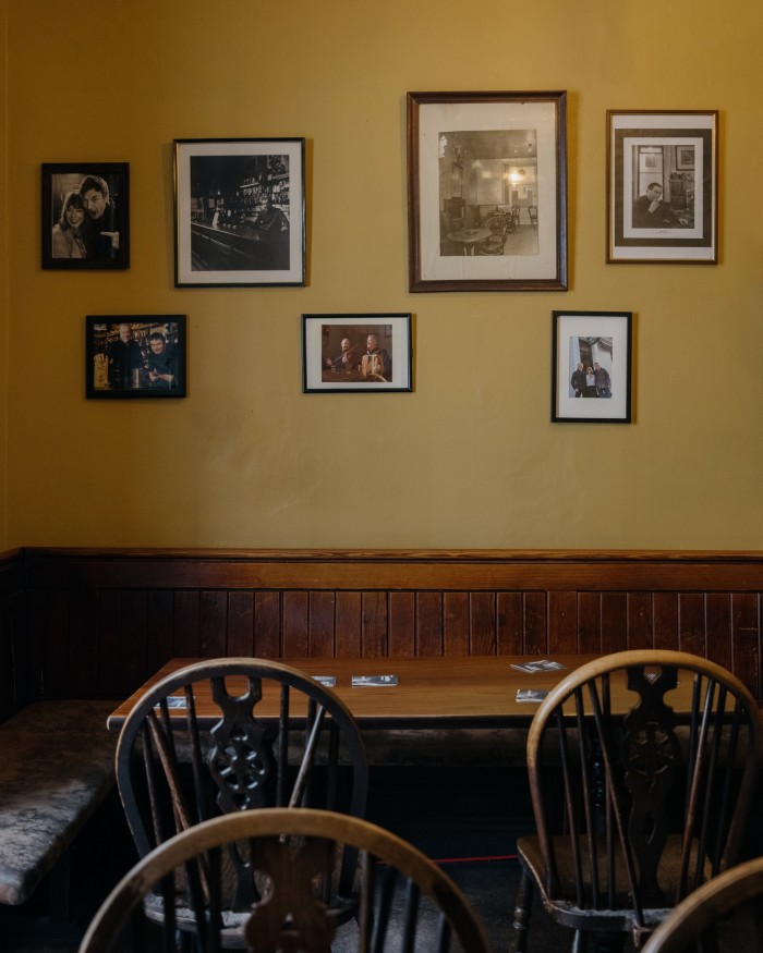 Framed photos on a yellow wall in The ‘Oxford’