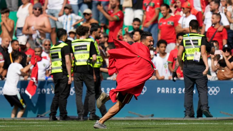 Invaders run on the pitch during the men's Group B soccer match between Argentina and Morocco at Geoffroy-Guichard Stadium at the 2024 Summer Olympics, Wednesday, July 24, 2024, in Saint-Etienne, France. (AP Photo/Silvia Izquierdo)