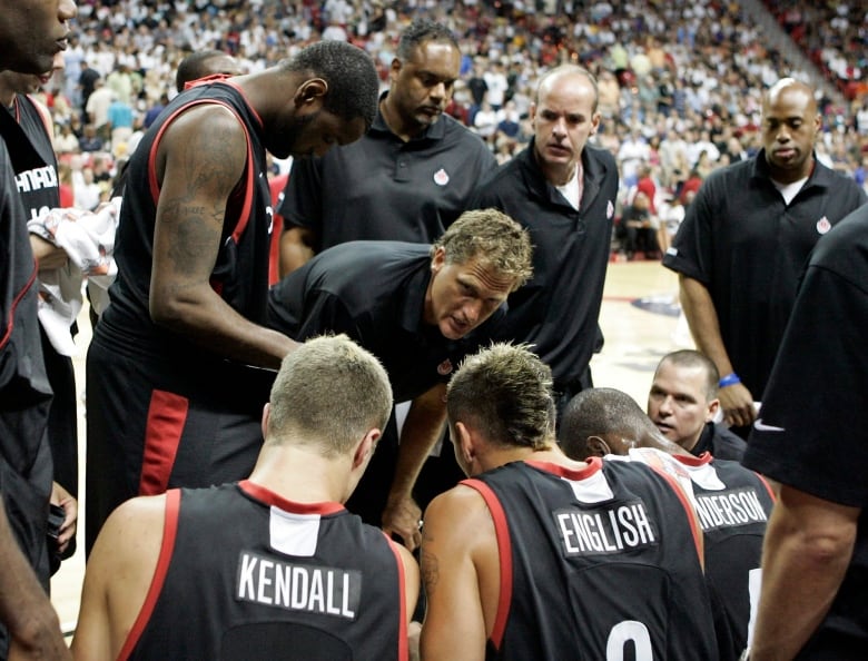 A basketball coach talks to a group of players.