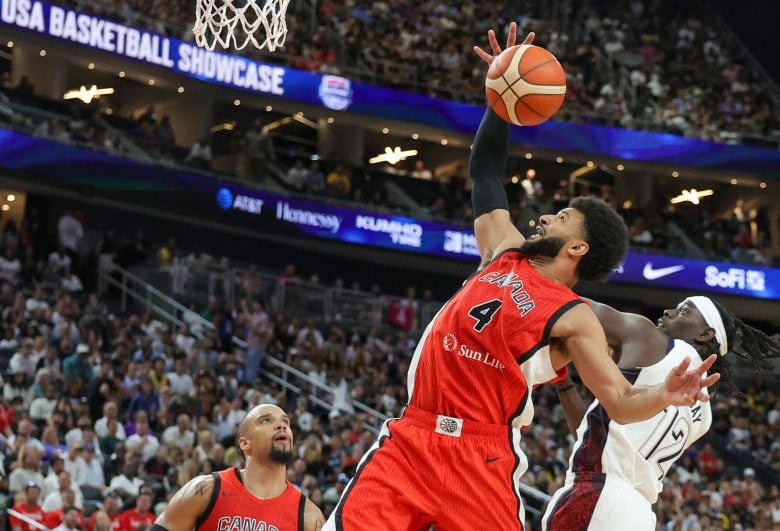 A basketball player grabs a rebound.